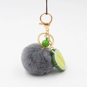 Creative durian charm keychain with grey plush fur ball and green bell on gold ring