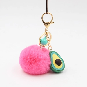 Detail of plush avocado keychain with magenta faux fur ball and blue bell ornament
