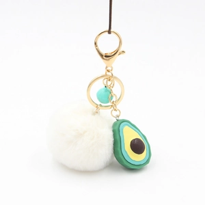 Cute avocado plush keychain with a white fluffy fur ball and gold metal clasp
