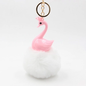 Detailed close-up of a pink swan keychain with a fluffy white plush pompom and gold ring