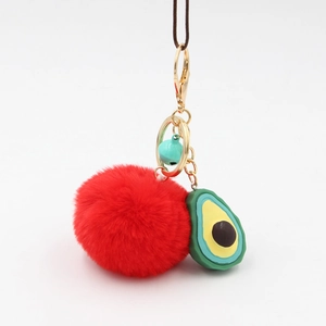 Cute avocado keychain featuring a plush red faux fur ball and gold metal bell charm