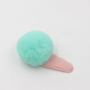 Détail de la pince à cheveux BB en velours côtelé rose avec pompon en fausse fourrure menthe