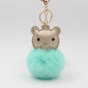 Détail du porte-clés avec boule en peluche vert menthe et petite tête d'ours en cuir