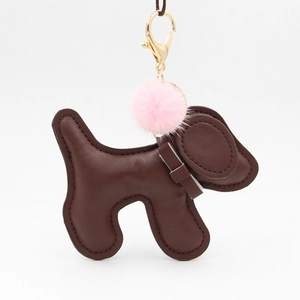 Detail of dark brown leather puppy keychain with pink pompom and gold lobster clasp