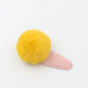 Vue détaillée de la pince à cheveux pompon jaune avec texture de clip BB rayée rose