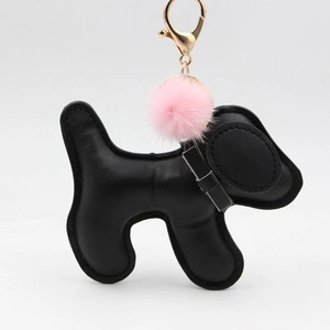 Cartoon black leather puppy keychain with a pink fluffy pompom and golden metal clasp