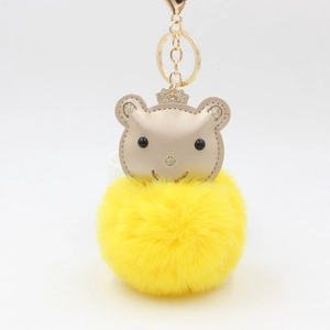 Porte-clés pompon jaune avec tête d'ours à couronne dorée et anneau métallique brillant
