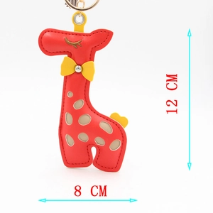 Detail showing 12cm red giraffe PU leather keychain with neat stitching and yellow bow