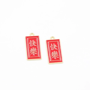 Macro detail of red and gold Chinese character charms for DIY jewelry and accessories