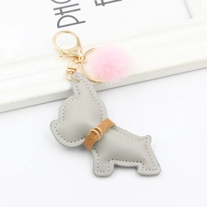 Detail of grey leather bulldog keychain with pink faux fur pompom and golden clasp