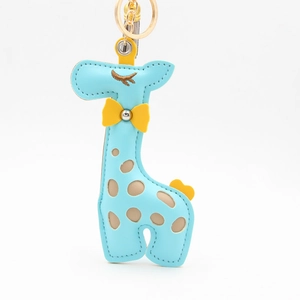Close-up of blue giraffe PU leather keychain with yellow bow and gold metal ring