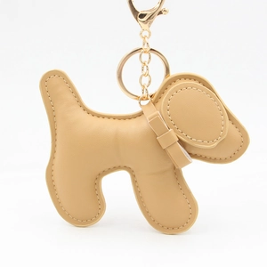 Detail of camel brown leather puppy keychain with gold clasp and fine stitching