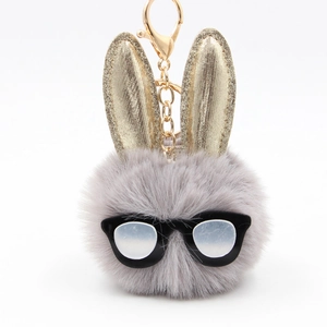 Dettaglio di un portachiavi a forma di coniglio grigio soffice con orecchie glitter oro