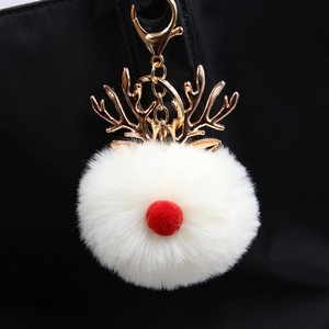 Christmas reindeer plush pompom keychain with gold antlers on a black bag strap