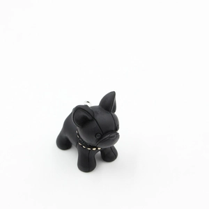 Gros plan du porte-clés bouledogue noir avec collier à clous dorés et anneau métal