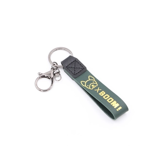 Vue détaillée de la sangle en cuir vert foncé avec logo bouledogue doré et fermoir en métal