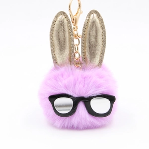 Dettaglio di un portachiavi a forma di coniglio in peluche viola con orecchie d'oro