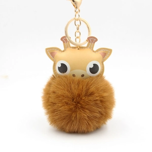 Detail eines gelben Leder-Giraffen-Schlüsselanhängers mit flauschigem braunem Pompon
