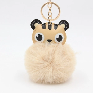 Détail de tête de tigre en cuir PU avec pompon doux et porte-clés en métal doré brillant