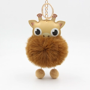 Close-up of cute cartoon giraffe plush keychain with large brown pompom and gold clip