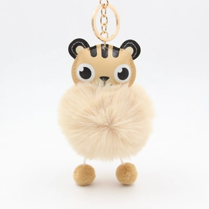 Detailed close-up of a tiger-themed faux leather and plush pompom keychain accessory