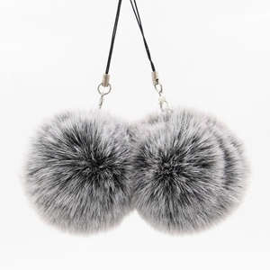 Close-up of fluffy grey and black faux fur pompom charms with silver lobster clasps