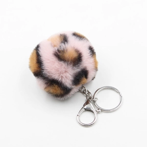 Detailed close-up of pink leopard print faux fur pompom keychain with silver lobster clasp
