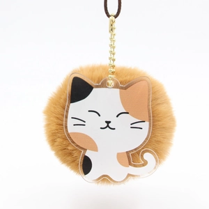 Détail d'un porte-clés chat en acrylique avec pompon en peluche marron et chaîne dorée