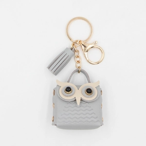 Detail of grey owl mini coin purse with golden keychain clasp and stylish tassel