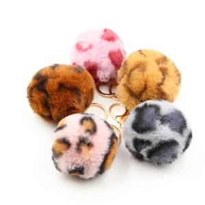 Detail view of five plush leopard print keychains with golden metal ring and lobster clasp