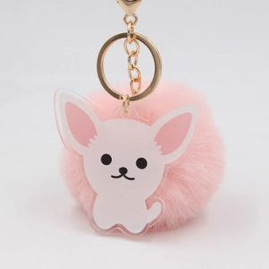 Détail du porte-clés pompon rose avec breloque chiot en acrylique et fermoir doré