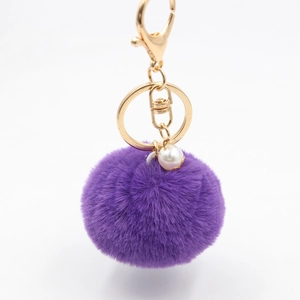 Purple plush fur ball keychain with white pearl accent and golden metal hardware