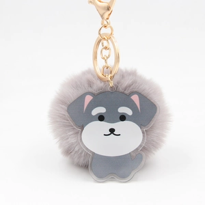 Détail d'un porte-clés pompon gris en fausse fourrure avec breloque chiot et fermoir doré chic