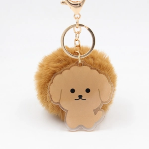Détail d'un porte-clés pompon en peluche marron avec un joli pendentif caniche acrylique