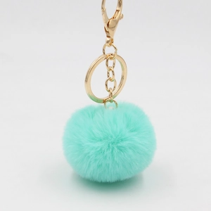 Vue détaillée du porte-clés pompon vert menthe avec fermoir mousqueton doré brillant