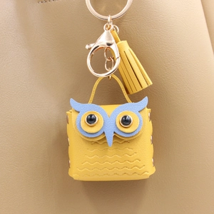 Macro shot of owl-shaped PU leather pouch with golden keychain and tassel detail