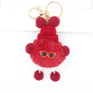 Détail du porte-clés monstre rouge en peluche avec bonnet en maille et fermoir doré