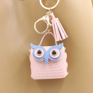 Close-up of pink PU leather owl bag charm with tassel and golden metal hardware clip