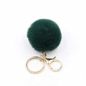 Détail du porte-clés pompon vert foncé en fausse fourrure avec anneau en métal doré