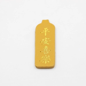 Detail of yellow PU leather keychain with lychee texture and gold embossed characters