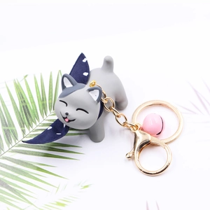 Cute gray resin cat keychain with pink bell and blue bow on a clean white background