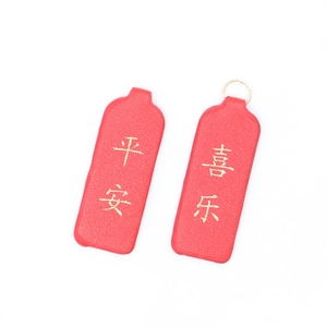 Detail view of two red PU leather tags with gold Peace and Joy Chinese characters