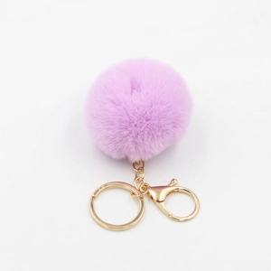 Vue détaillée du porte-clés pompon en fausse fourrure rose avec fermoir mousqueton doré