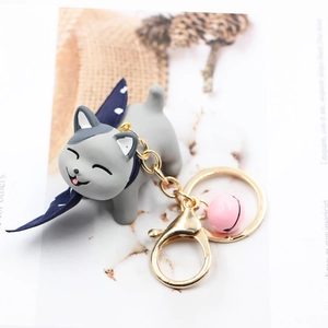 Detailed shot of cute grey resin cat keychain with blue scarf and pink bell accent