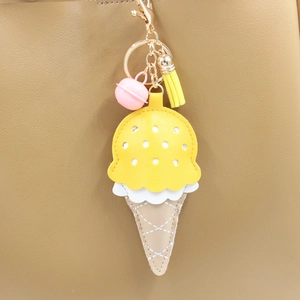 Détail du porte-clés crème glacée en PU avec clochette rose et gland jaune sur un sac