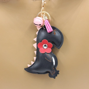 Cartoon black PU leather dinosaur keychain with pink tassel and bell on a bag
