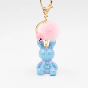 Detail of blue purple polarized rabbit pendant with pink faux fur pompom and heart bell
