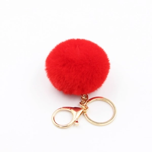 Vue détaillée d'un porte-clés pompon rouge de 6cm avec fermoir mousqueton doré élégant