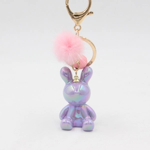 Detail of purple iridescent gradient rabbit keychain with a pink fluffy pompom accessory