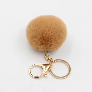 Détail d'un porte-clés pompon en fausse fourrure kaki de 6cm avec fermoir doré brillant